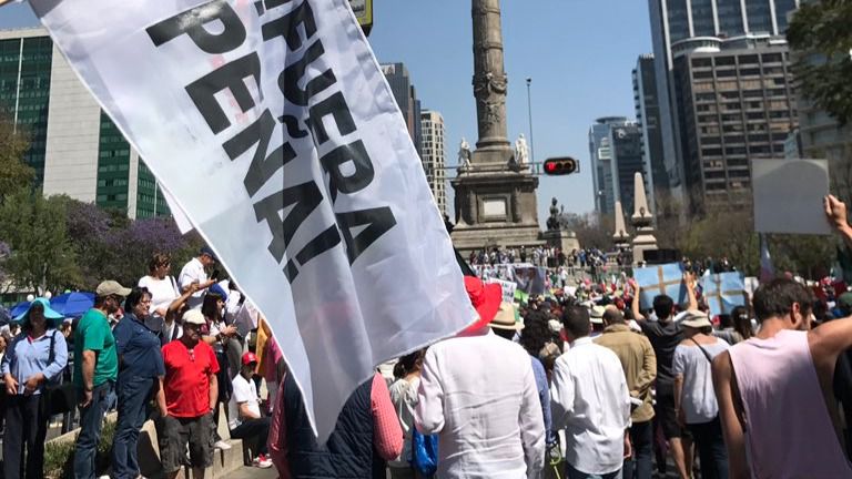 Un grupo de manifestantes con una pancarta contraria a Peña Nieto en México