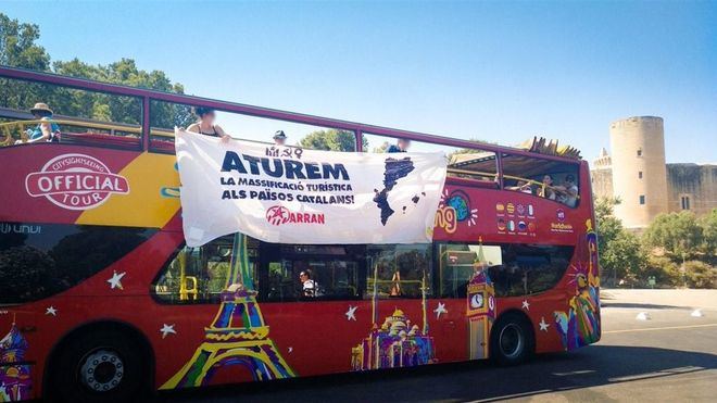 Arran arremete contra un bus con botes de humo y pancartas por 'la masificación en los Països Catalans'